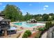 Large community pool area with a slide, tables, and ample seating, perfect for relaxation and recreation at 400 Maymont Dr, Cramerton, NC 28032