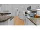 Bright kitchen boasts granite countertops, stainless appliances, white cabinetry and hardwood floors at 400 Maymont Dr, Cramerton, NC 28032