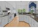 Open kitchen with granite counters, white cabinets, stainless steel appliances, and sun-filled eating nook at 400 Maymont Dr, Cramerton, NC 28032