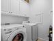 Functional laundry room featuring a front-loading washer and dryer, upper cabinets for storage at 400 Maymont Dr, Cramerton, NC 28032