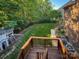 Spacious backyard featuring a wooden deck, lush lawn, mature trees, and a playhouse for outdoor enjoyment at 4006 Tremont Dr, Indian Trail, NC 28079