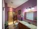 Charming bathroom showcasing a tiled shower with glass doors, granite countertop, and purple walls at 4006 Tremont Dr, Indian Trail, NC 28079