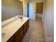 Bathroom with double sinks, tile floors, and well-lit with access to a full tub with tile surround at 4006 Tremont Dr, Indian Trail, NC 28079