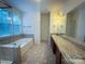 Large bathroom featuring a soaking tub and double vanity with granite counters at 4006 Tremont Dr, Indian Trail, NC 28079