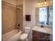 Well-lit bathroom with vanity, toilet, and tiled shower at 4006 Tremont Dr, Indian Trail, NC 28079