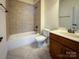 Bathroom with tiled shower-tub combo, toilet, and vanity, with neutral tiling throughout at 4006 Tremont Dr, Indian Trail, NC 28079