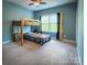 Cozy bedroom featuring a wooden bunk bed, a window with curtains, and soft carpet flooring at 4006 Tremont Dr, Indian Trail, NC 28079