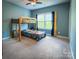 Bright bedroom featuring a bunk bed, window, blue accent wall, and neutral carpet at 4006 Tremont Dr, Indian Trail, NC 28079