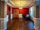 Formal dining room with hardwood floors, red walls, and elegant chandelier at 4006 Tremont Dr, Indian Trail, NC 28079