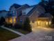 Charming two-story brick home featuring an attached two car garage and manicured landscaping during the evening at 4006 Tremont Dr, Indian Trail, NC 28079