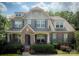 Charming two-story brick home featuring a stone entrance, covered porch, and beautifully landscaped front yard at 4006 Tremont Dr, Indian Trail, NC 28079