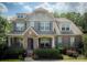 Charming brick home with stone accents, blue shutters, covered porch, and manicured landscaping at 4006 Tremont Dr, Indian Trail, NC 28079
