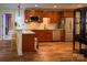 Well-lit kitchen featuring granite countertops, wood cabinets, stainless steel appliances, and hardwood floors at 4006 Tremont Dr, Indian Trail, NC 28079