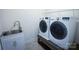Functional laundry room equipped with a sink, washing machine, dryer, and storage shelf at 4006 Tremont Dr, Indian Trail, NC 28079