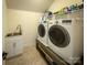 Well-equipped laundry room with modern washer, dryer, sink, and shelving at 4006 Tremont Dr, Indian Trail, NC 28079