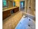 Main bathroom featuring a soaking tub, tiled floors, double vanity, and walk-in shower at 4006 Tremont Dr, Indian Trail, NC 28079