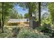 Lush backyard featuring mature trees, a custom treehouse, wooden fence, and brick accents at 405 Scarborough Ln, Matthews, NC 28105