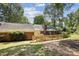 Expansive backyard featuring a patio, pergola, brick details, and wooden fence, surrounded by lush greenery at 405 Scarborough Ln, Matthews, NC 28105