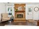 Classic brick fireplace with decorative mantel and hearth, adjacent to a sunny window and doorway at 405 Scarborough Ln, Matthews, NC 28105
