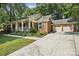 Charming brick home featuring an inviting front porch, well-manicured landscaping, and an attached two-car garage at 405 Scarborough Ln, Matthews, NC 28105