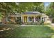 Charming brick home featuring an inviting front porch with a yellow door and blue shutters at 405 Scarborough Ln, Matthews, NC 28105