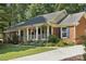 Charming brick home featuring an inviting front porch, well-manicured landscaping, and blue shutters at 405 Scarborough Ln, Matthews, NC 28105