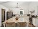 Well-lit kitchen with white cabinets, marble counters, stainless appliances, large center island and seating for two at 405 Scarborough Ln, Matthews, NC 28105