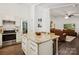 Stylish kitchen island with granite countertops and seating, with appliances and adjacent living room in view at 405 Scarborough Ln, Matthews, NC 28105
