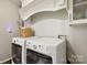 Well-lit laundry room with white washer and dryer units at 405 Scarborough Ln, Matthews, NC 28105