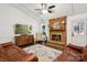 Cozy living room featuring a brick fireplace, wood flooring, comfortable leather furniture, and ceiling fan at 405 Scarborough Ln, Matthews, NC 28105