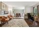 Bright living room with hardwood floors, vintage rug, and open access to the dining room and an office space at 405 Scarborough Ln, Matthews, NC 28105