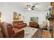 Inviting living room with brick fireplace, comfortable leather sofas, a ceiling fan, and stylish wood accents at 405 Scarborough Ln, Matthews, NC 28105