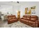 Bright and open living room featuring a leather sofa, wood flooring, and a view of the modern kitchen at 405 Scarborough Ln, Matthews, NC 28105