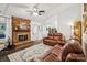 Cozy living room with a brick fireplace, plush leather furniture, and stylish area rug at 405 Scarborough Ln, Matthews, NC 28105