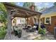 Relaxing outdoor space featuring a brick floor, pergola with lights, grill and wicker furniture at 405 Scarborough Ln, Matthews, NC 28105