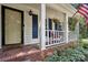 Inviting front porch featuring brick flooring, hanging flower baskets, and charming white railing at 405 Scarborough Ln, Matthews, NC 28105