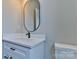 Neutral bathroom featuring white vanity with black hardware, oval mirror, and toilet at 418 Harrison St, Statesville, NC 28677