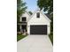 Charming two-story home with a black garage door, light grey driveway, and a well-manicured lawn at 418 Harrison St, Statesville, NC 28677