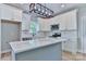 Bright kitchen with white cabinets, subway tile backsplash, stainless appliances, and a large grey island at 418 Harrison St, Statesville, NC 28677