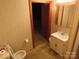 Bathroom featuring a toilet, sink and vanity, and patterned wallpaper at 4476 Nc Hwy 200 Rd, Stanfield, NC 28163