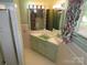 Retro bathroom with green sink and vanity, featuring unique mirror and tile design at 4476 Nc Hwy 200 Rd, Stanfield, NC 28163