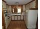 Charming kitchen with white cabinets, a window above the sink, and white appliances at 4476 Nc Hwy 200 Rd, Stanfield, NC 28163