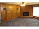 Relaxing living room with cozy fireplace and wooden paneling at 4476 Nc Hwy 200 Rd, Stanfield, NC 28163