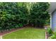 Serene backyard featuring artificial turf, lush greenery, and privacy fencing at 4516 Night Heron Ln, Charlotte, NC 28211