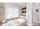 Bright bathroom featuring a soaking tub with open window and decorative shelving at 4516 Night Heron Ln, Charlotte, NC 28211