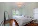Light-filled bedroom with hardwood floors, bright walls, and a decorative light fixture at 4516 Night Heron Ln, Charlotte, NC 28211