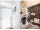 This laundry room features modern washer and dryer units, wooden accent wall and access to the exterior at 4516 Night Heron Ln, Charlotte, NC 28211
