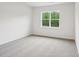 A carpeted bedroom with a large window overlooking trees and outdoor scenery at 4619 Harris Elliot Rd, Lincolnton, NC 28092
