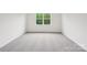 A carpeted bedroom with a large window overlooking outdoor scenery at 4619 Harris Elliot Rd, Lincolnton, NC 28092
