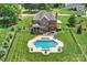 Aerial view of a backyard with a pool, patio area, lush landscaping, and a well-maintained lawn at 4941 Campobello Dr, Monroe, NC 28110